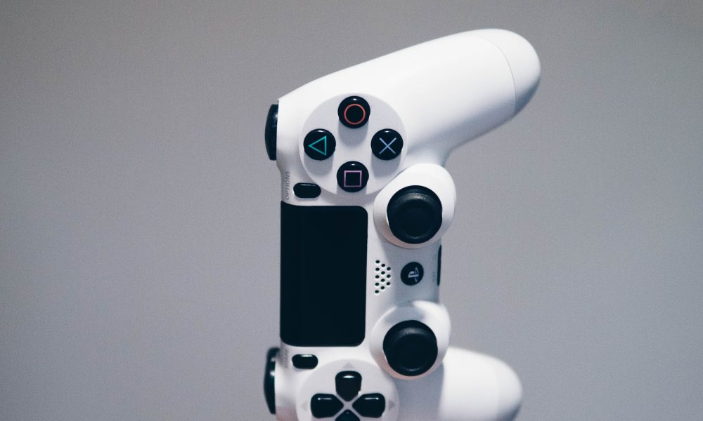 White Sony controller falling into someones hands. Photo courtesy of Nikita Kachanovsky on Unsplash.