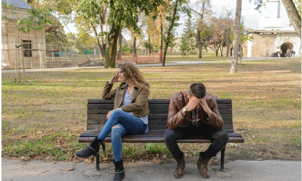 Woman And Man Sitting on Brown Wooden Bench by Vera Arsic