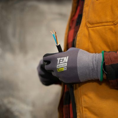 An electrician with work gloves holding a wire. Photo courtesy of Jimmy Nilsson Masth on Unsplash.