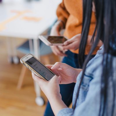 Photo of two people on their phone courtesy of Jason Goodman on Unsplash.