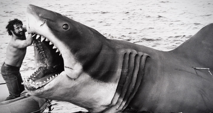 Image of the puppet shark from Jaws, with Steven Spielberg holding its mouth open